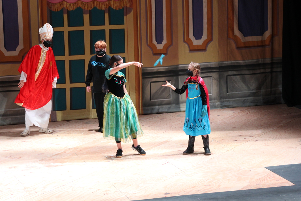 Students in costumes on stage.